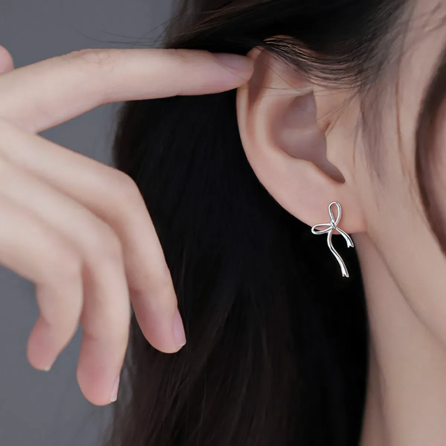 Серебряные асимметричные серьги с бантом и круглым подвесом