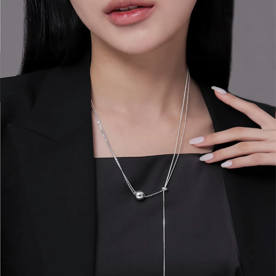 Серебристое колье с двойной тонкой цепочкой и подвеской в виде круглого шарика