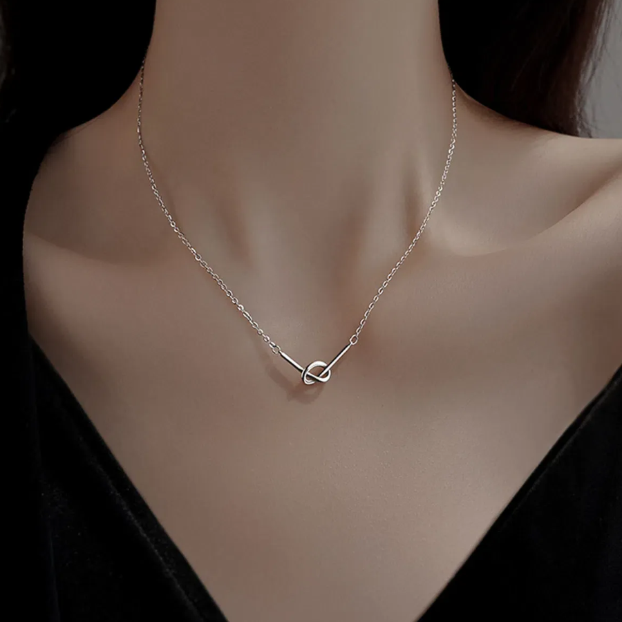 Серебристое колье с простой линией и плетёной подвеской в форме кренделя