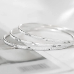 Тонкий серебряный браслет-бэнгл с гравировкой и сверкающими акцентами, универсального размера