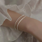 Серебряный браслет с двумя блестящими цепочками и мелкими серебряными бусинами