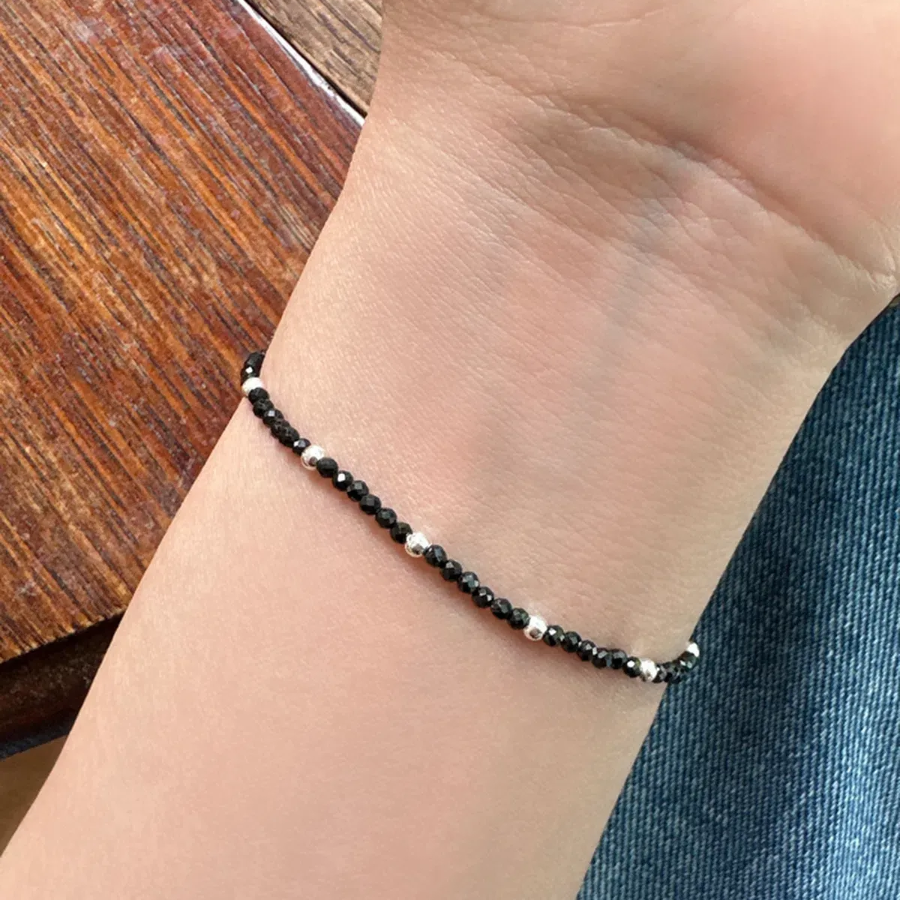 Серебряный браслет с чёрными бусинами на эластичной основе