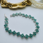 Браслет-теннис с зелёными кубическими цирконами и четырёхлистным клевером из хирургической стали