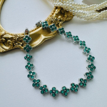 Браслет-теннис с зелёными кубическими цирконами и четырёхлистным клевером из хирургической стали