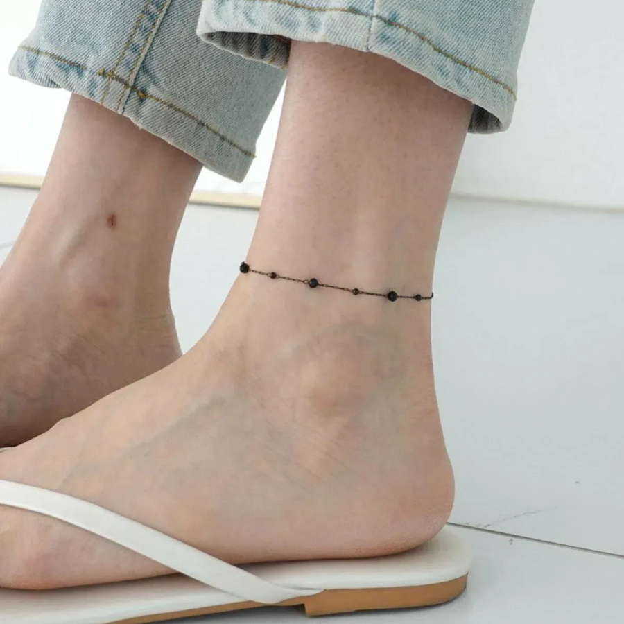 Браслет на ногу с круглыми черными бусинками и элементами из хирургической стали