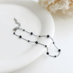Браслет на ногу с круглыми черными бусинками и элементами из хирургической стали
