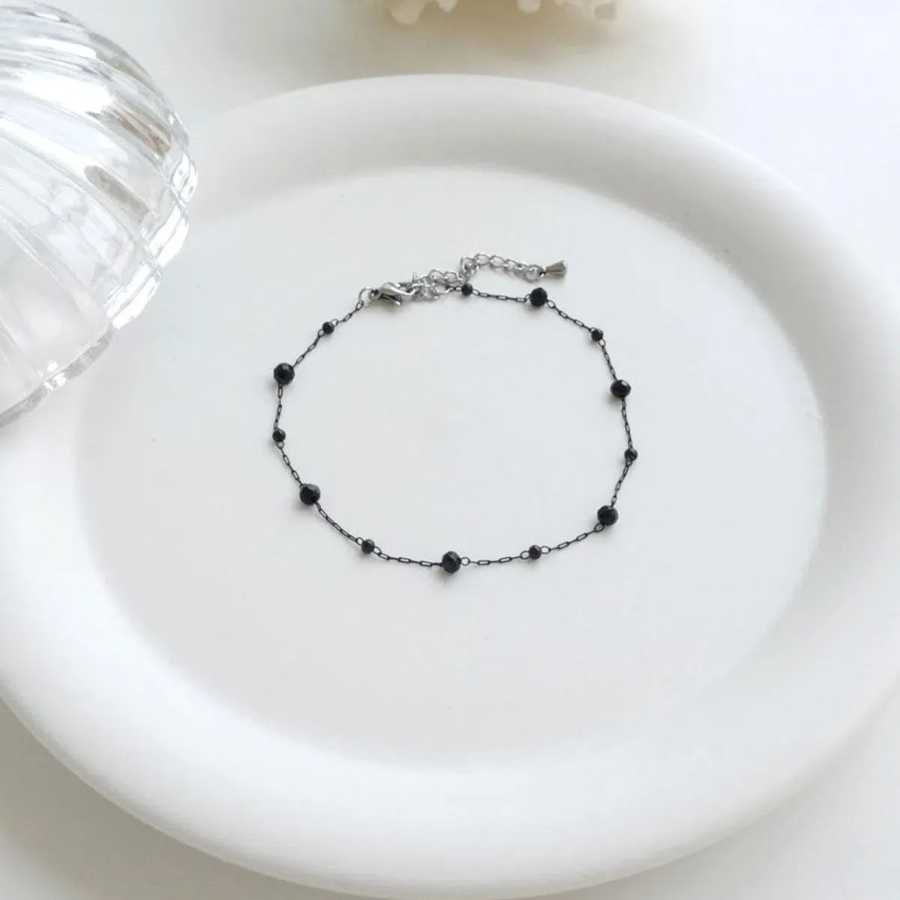 Браслет на ногу с круглыми черными бусинками и элементами из хирургической стали