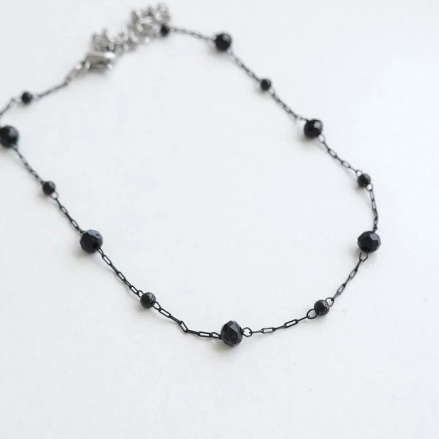 Браслет на ногу с круглыми черными бусинками и элементами из хирургической стали