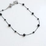 Браслет на ногу с круглыми черными бусинками и элементами из хирургической стали