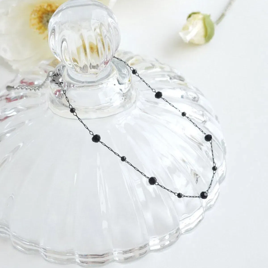 Браслет на ногу с круглыми черными бусинками и элементами из хирургической стали